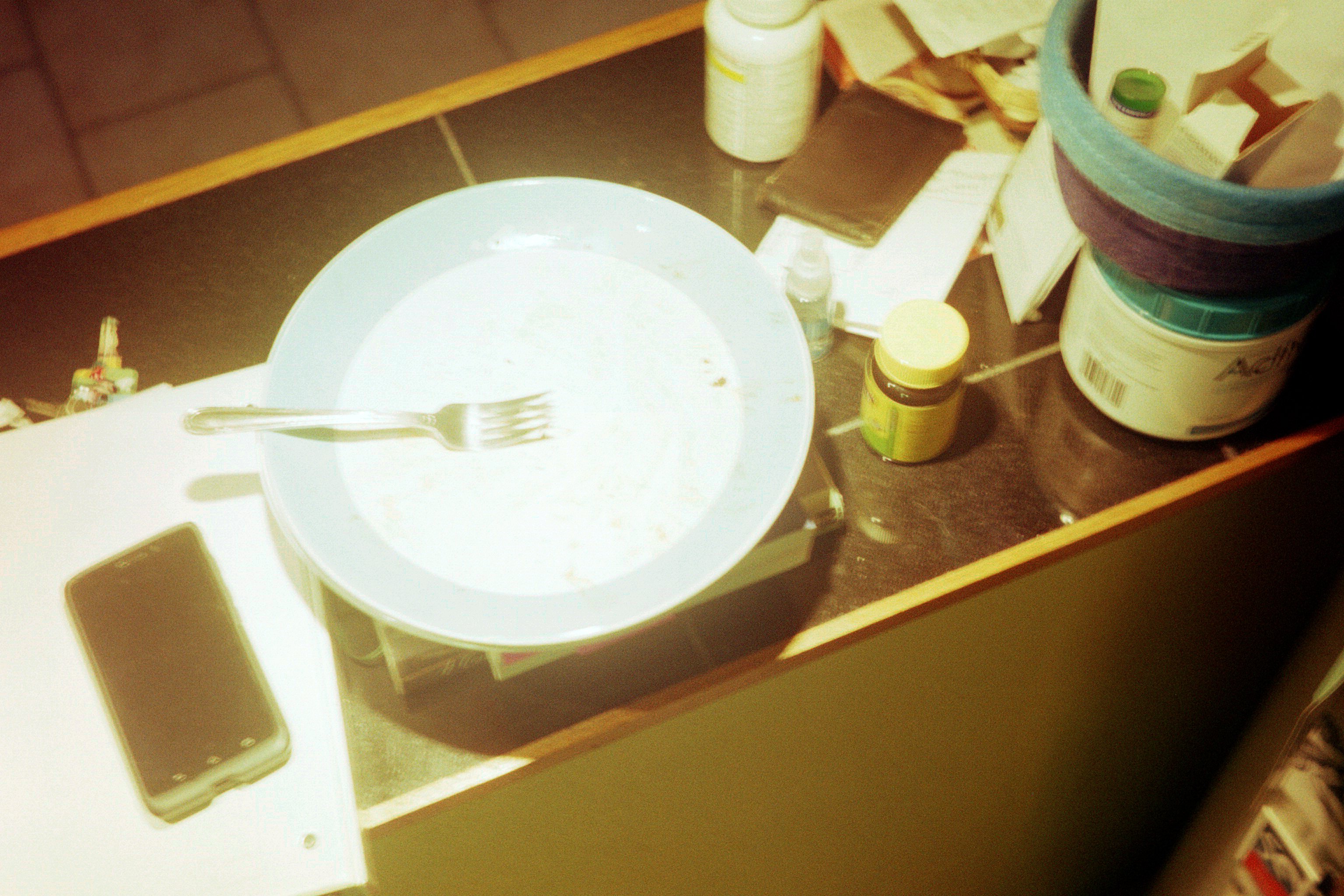 An empty plate with fork, lit harshly from above (I honestly don't know what I was thinking with this one)